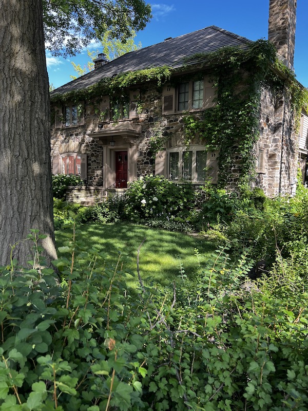 A beautiful stone house covered in greenery