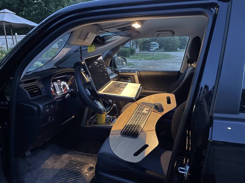 My work station in our old 4Runner with my laptop on a steering wheel stand and a lap board with my keyboard and mouse on it