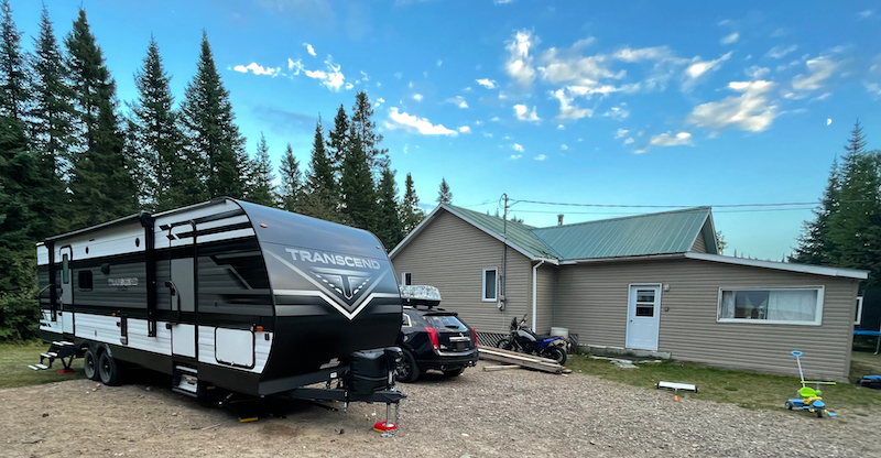 The camper backed into the driveway of the cabin