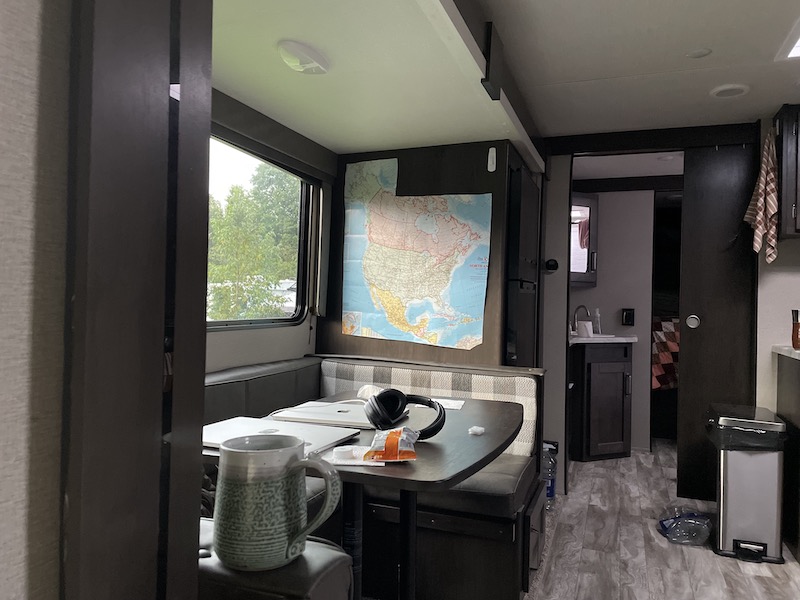 The inside of our camper, the table with some stuff on it, our map that we brought over from Yolonda