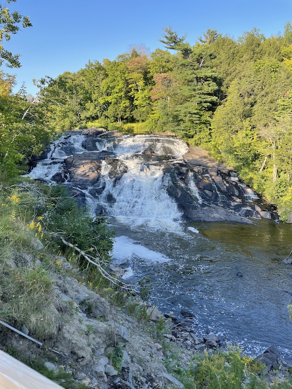 A large rock face waterfall along a river near Shawinigan