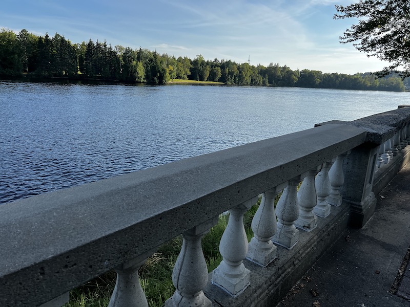 The river in Shawinigan beyond a short, thick decorated stone fence that lines the city river