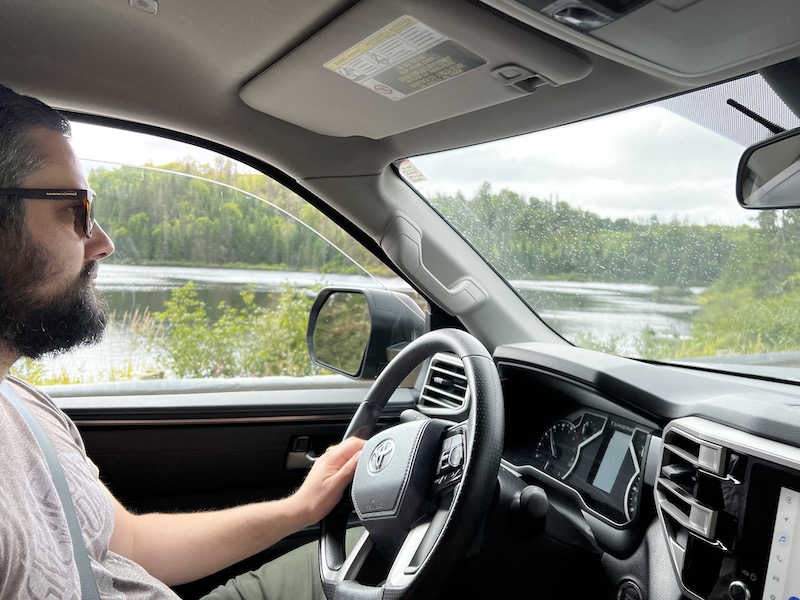 Me driving the truck in some slight rain with a river in the background